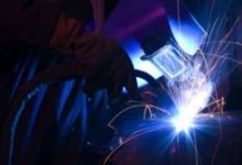 Dramatic blue-lit MIG welding close